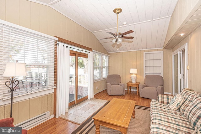 living room with wooden walls, light hardwood / wood-style floors, and lofted ceiling