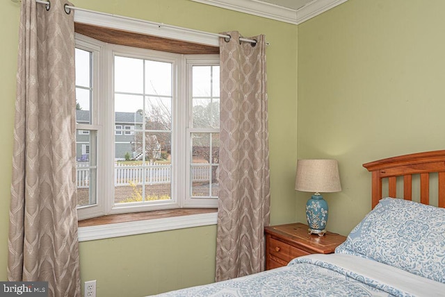 bedroom featuring ornamental molding and multiple windows