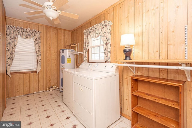 laundry area featuring wood walls, water heater, washer and dryer, and ceiling fan