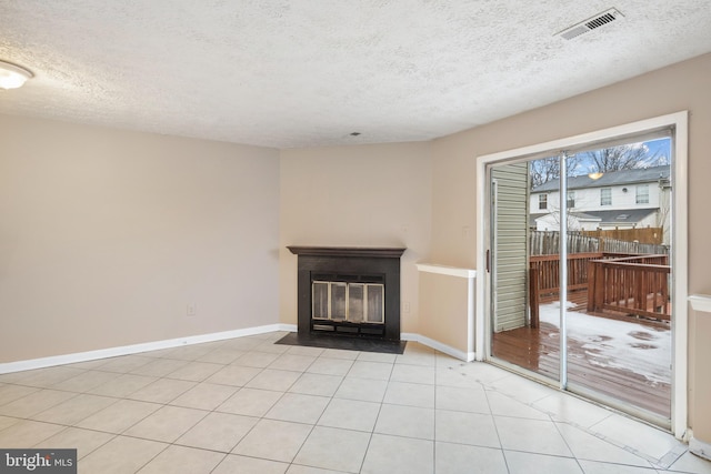 unfurnished living room featuring a textured ceiling and light tile patterned floors