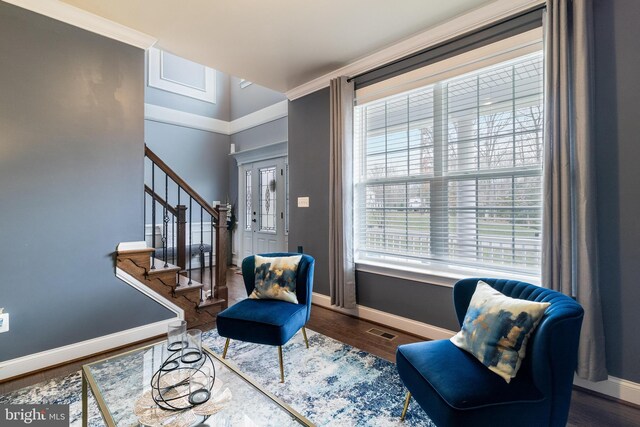 living area featuring stairway, baseboards, visible vents, and wood finished floors