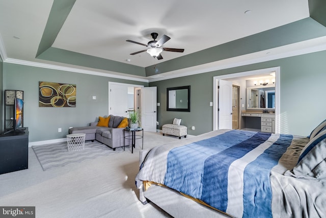 bedroom with ornamental molding, a tray ceiling, and light colored carpet