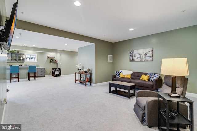 living area featuring baseboards, recessed lighting, visible vents, and light colored carpet