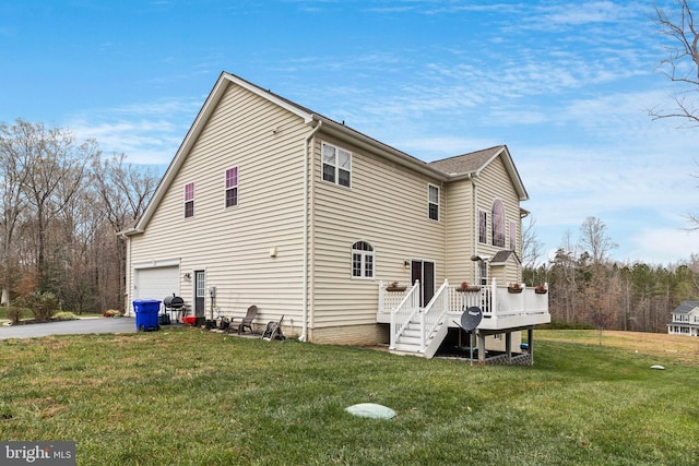 view of side of property with aphalt driveway, an attached garage, a lawn, and a wooden deck