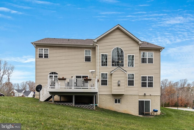 rear view of property featuring a deck, a lawn, and stairs