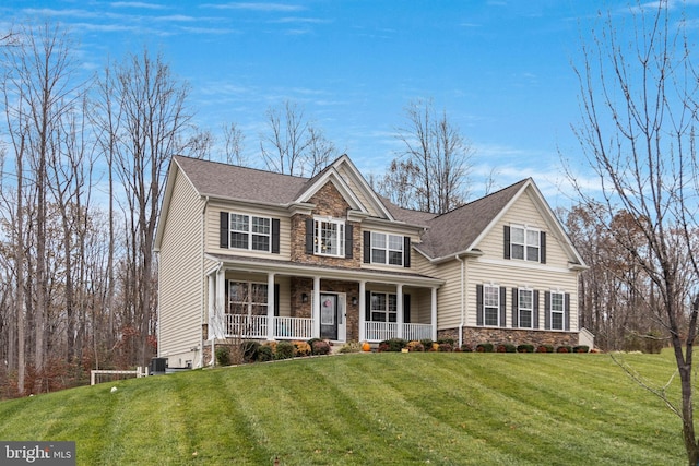 view of front of house with stone siding, central AC unit, a porch, and a front yard