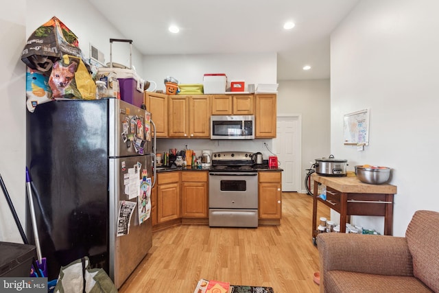 kitchen with light hardwood / wood-style flooring and appliances with stainless steel finishes