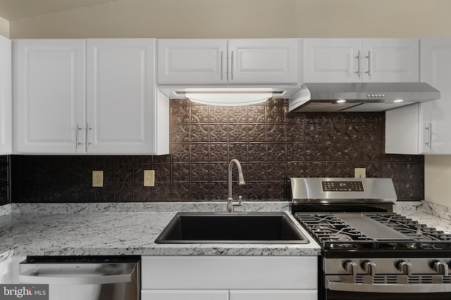 kitchen with white cabinetry, sink, stainless steel appliances, wall chimney range hood, and decorative backsplash