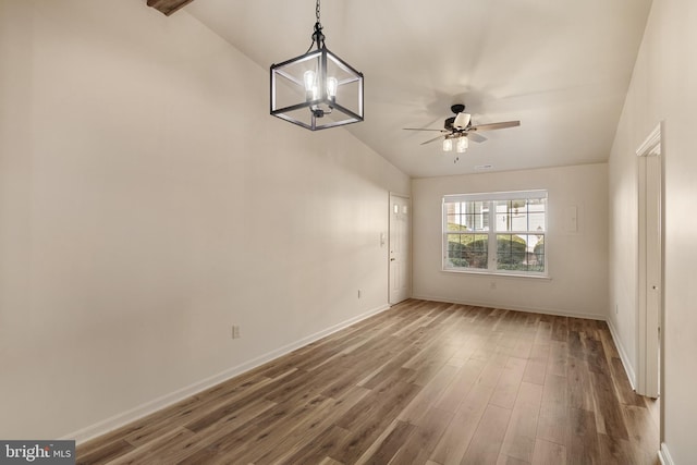 unfurnished room with hardwood / wood-style floors, ceiling fan with notable chandelier, and lofted ceiling