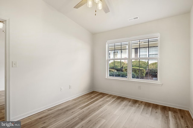 empty room with ceiling fan, light hardwood / wood-style floors, and vaulted ceiling