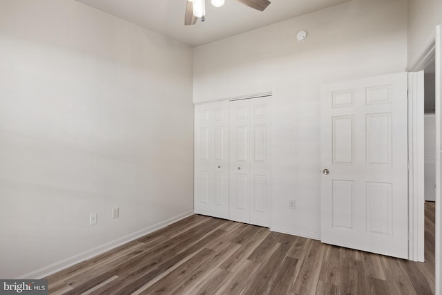 unfurnished bedroom with wood-type flooring, a closet, and ceiling fan