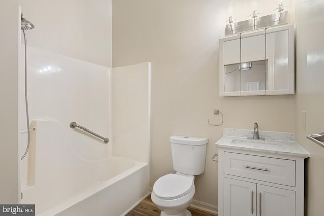 full bathroom with vanity, toilet, wood-type flooring, and washtub / shower combination