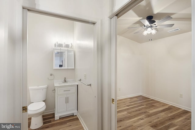 bathroom featuring hardwood / wood-style floors, vanity, toilet, and ceiling fan