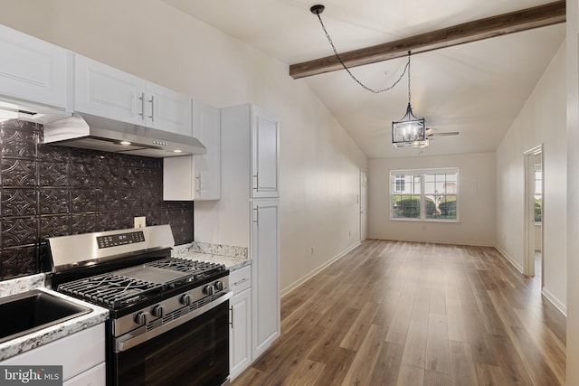 kitchen with white cabinetry, stainless steel gas stove, lofted ceiling with beams, and light hardwood / wood-style flooring