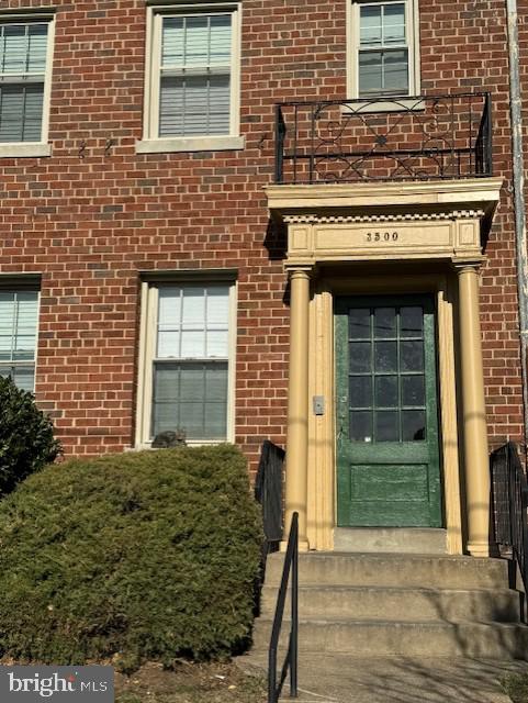 view of exterior entry featuring a balcony