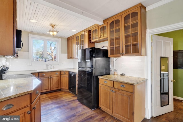 kitchen featuring backsplash, dark hardwood / wood-style floors, light stone counters, and black appliances