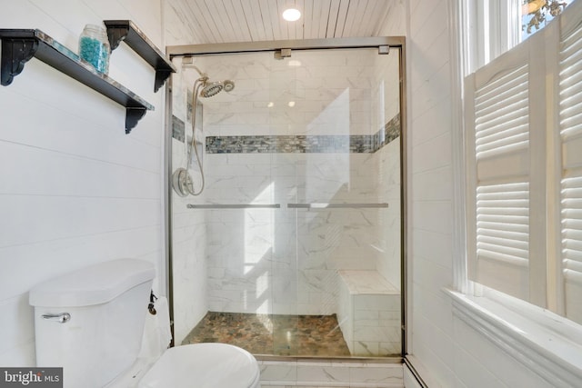 bathroom with a shower with shower door and toilet