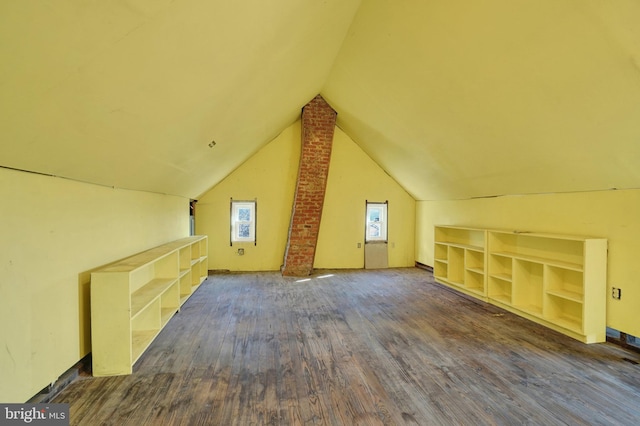 additional living space featuring built in shelves, dark hardwood / wood-style flooring, and vaulted ceiling