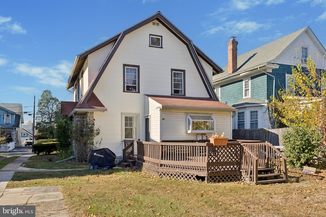 rear view of house with a deck and a lawn