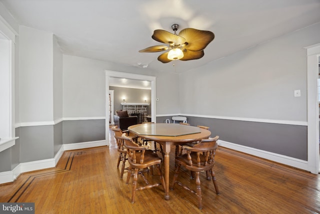 dining space with ceiling fan and wood-type flooring