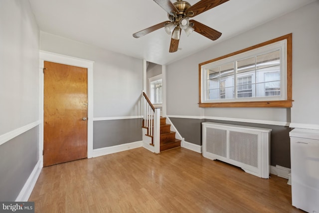 entryway with radiator, ceiling fan, plenty of natural light, and light wood-type flooring