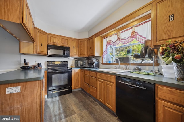 kitchen with black appliances, dark hardwood / wood-style floors, and sink