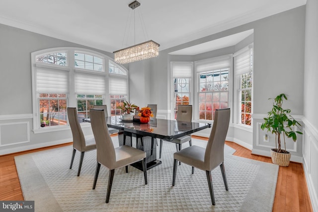 7238 Farr St, Annandale, VA 22003 - dining space featuring a chandelier, healthy amount of natural light, wainscoting, wood finished floors, and ornamental molding