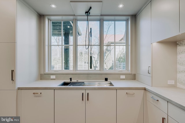 kitchen with white cabinets, plenty of natural light, and sink