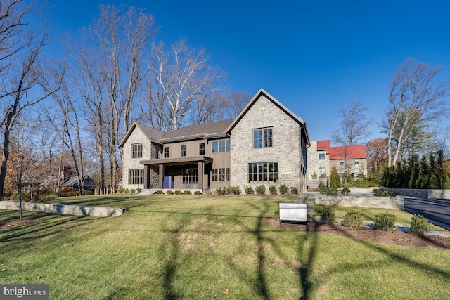 rear view of house featuring a porch and a yard