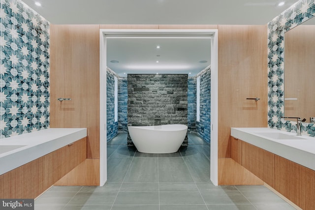 bathroom with a tub to relax in, tile patterned flooring, and vanity