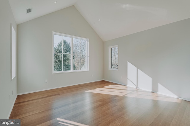 unfurnished room featuring light hardwood / wood-style floors and lofted ceiling