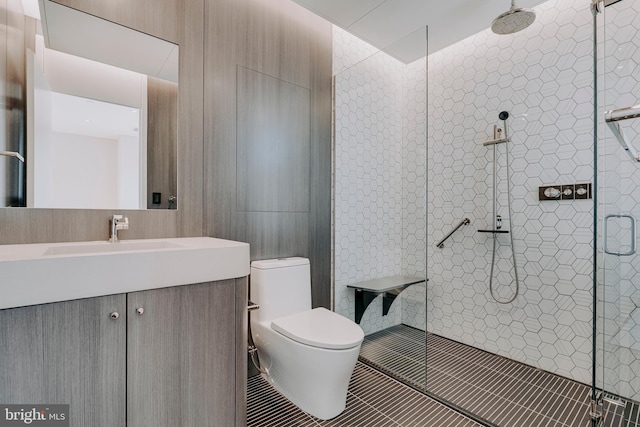 bathroom with tile patterned floors, vanity, toilet, and a shower with shower door