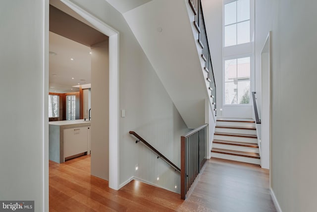 stairs featuring hardwood / wood-style floors and sink