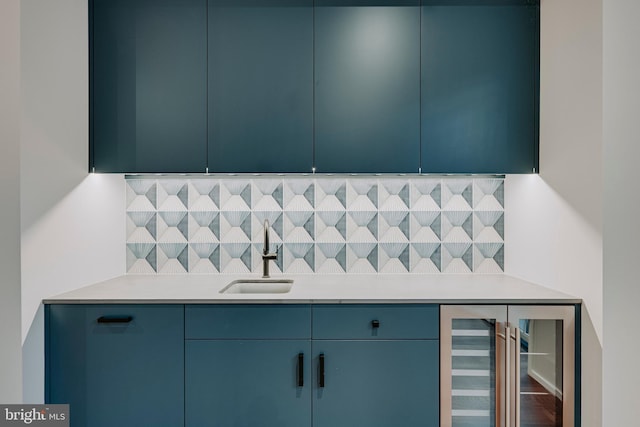 kitchen featuring blue cabinetry, sink, and wine cooler