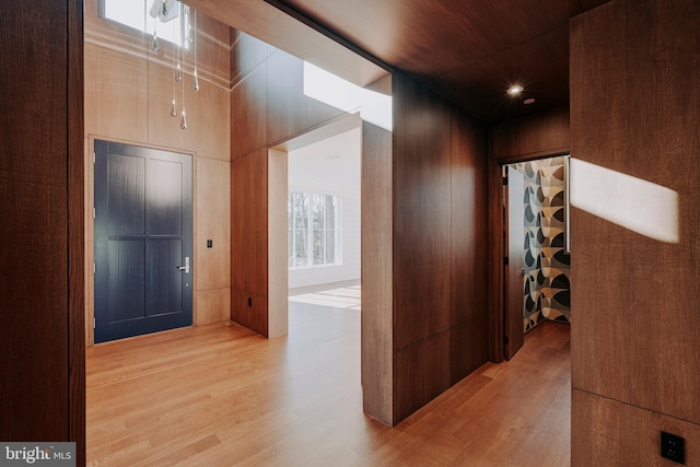 corridor with wood walls, wood ceiling, and hardwood / wood-style flooring