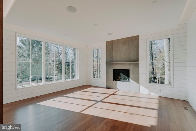 unfurnished living room with dark hardwood / wood-style floors, a healthy amount of sunlight, and a fireplace