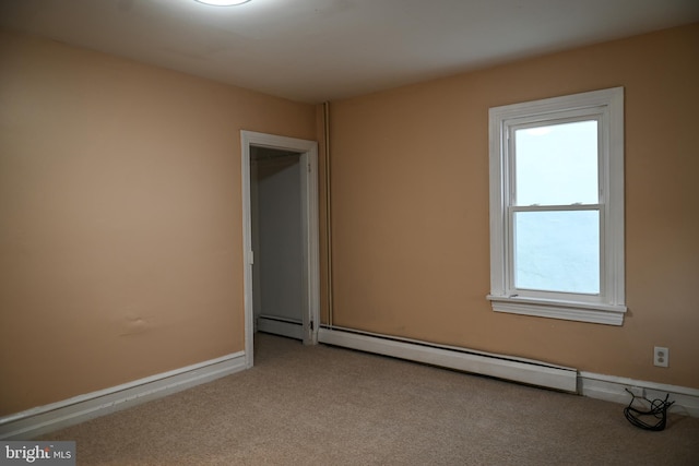 carpeted empty room featuring a baseboard heating unit