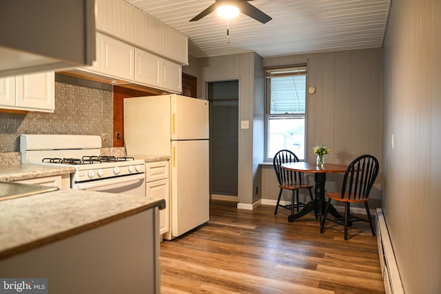 kitchen featuring hardwood / wood-style floors, white cabinets, white appliances, and baseboard heating