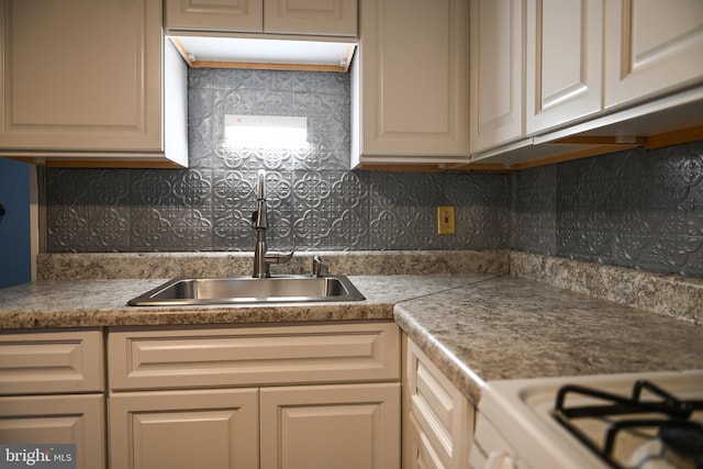 kitchen featuring cream cabinetry, tasteful backsplash, and sink