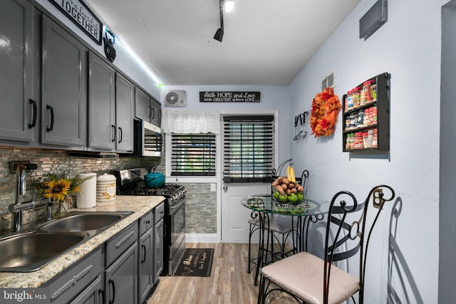 kitchen with gray cabinets, sink, stainless steel appliances, and wood-type flooring