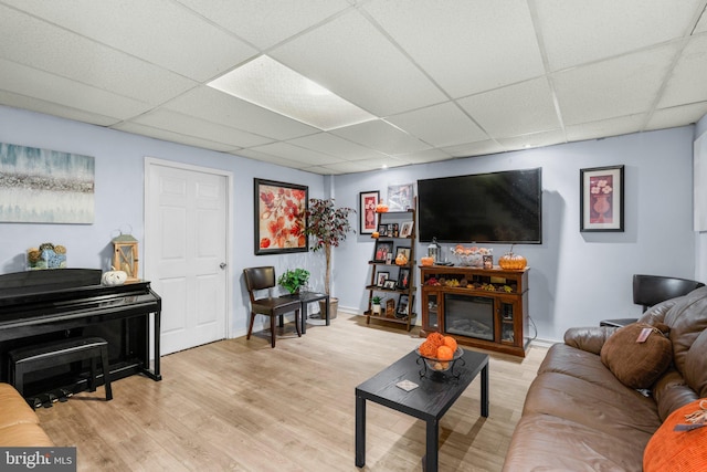 living room featuring a paneled ceiling and light hardwood / wood-style flooring