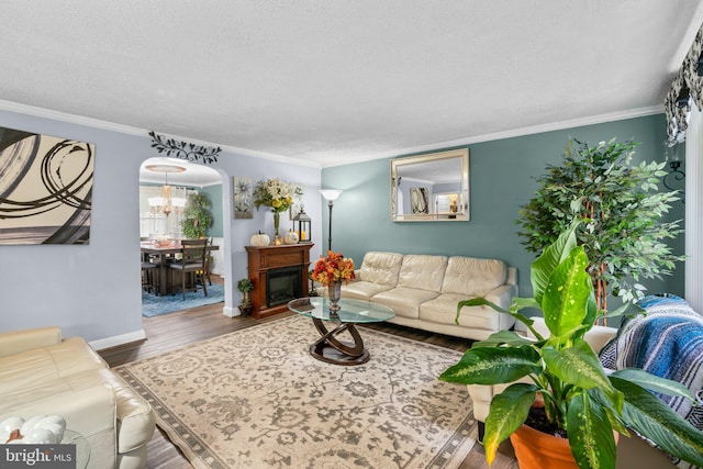 living room featuring a textured ceiling, wood-type flooring, and crown molding