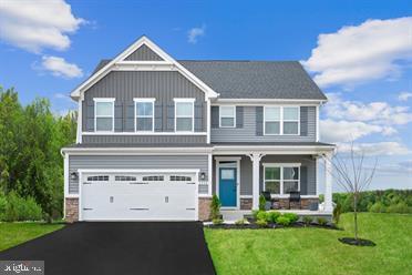 view of front of home with a front yard, a porch, and a garage