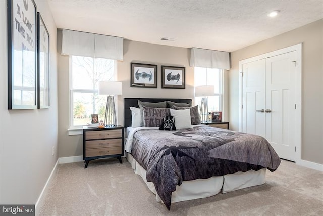 carpeted bedroom featuring a closet and a textured ceiling