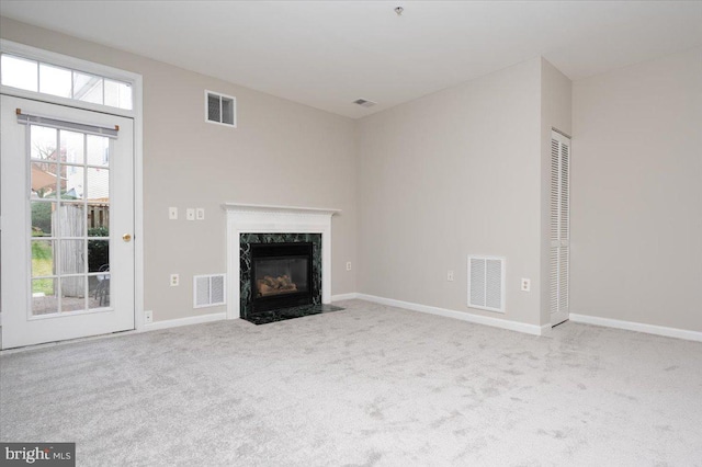 unfurnished living room with light carpet and a fireplace