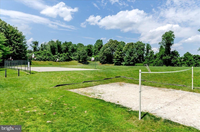 view of community with volleyball court, a yard, and a rural view