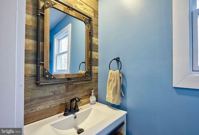 bathroom with sink and wood walls