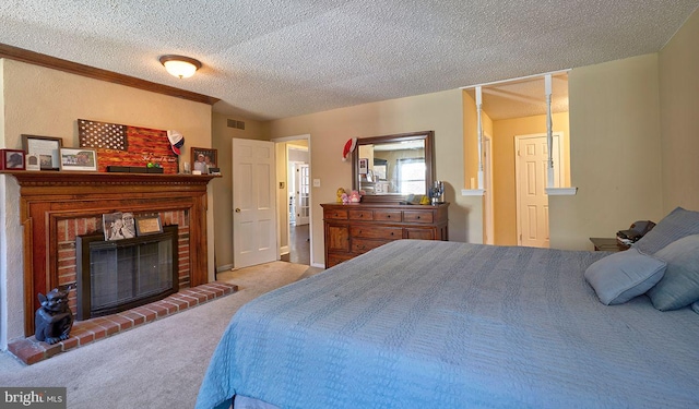 carpeted bedroom featuring a textured ceiling and a brick fireplace