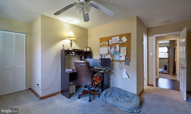 carpeted office with ceiling fan and a textured ceiling