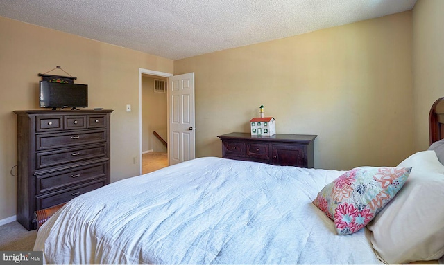 bedroom with light carpet and a textured ceiling